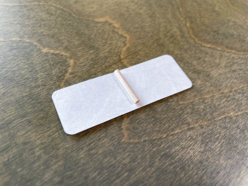 place the tiny dowel in the middle of the label